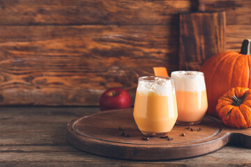 Glasses of tasty pumpkin smoothie on table