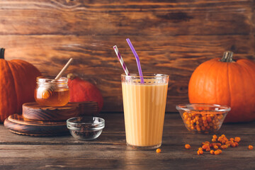 Glass of tasty pumpkin smoothie on table
