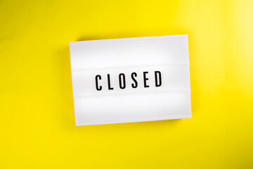 Closed word on lightbox, vintage billboard on yellow background isolated. Global crisis, quarantine due to covid-19, shutdown of restaurants. Second wave of coronavirus, covid-19 pandemic, lockdown