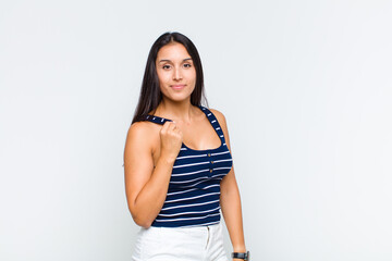 young woman looking arrogant, successful, positive and proud, pointing to self