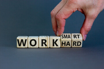 Work hard or work smart. Hand turns cubes and changes the words 'work hard' to 'work smart'. Beautiful grey background. Business and work smarter concept, copy space. - obrazy, fototapety, plakaty