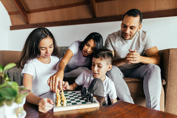 Family playing chess together in the living room