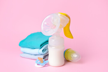Breast pump and baby accessories on color background