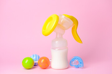 Breast pump and baby accessories on color background