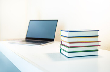 Desk with a Laptop and Stacked Books. Study table or work table.