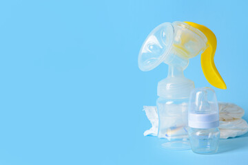 Breast pump and baby accessories on color background