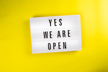 Yes We Are Open message on lightbox on yellow background isolated. quarantine opening, isolation end concept. Recovery of economic activity after global crisis concept
