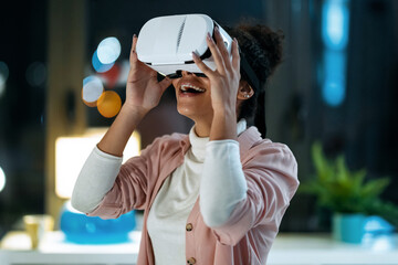 Modern young entrepreneur woman using virtual reality headset and enjoying the moment in the office.