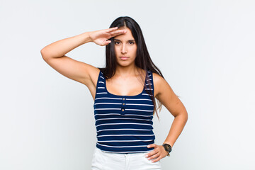 young woman greeting the camera with a military salute in an act of honor and patriotism, showing...