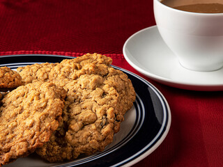Raisin Oatmeal Cookies on a Plate with a Side of Coffee in a White Cup
