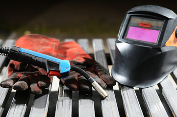 Photo of welding gloves, electrode holder, welder's mask in the workshop