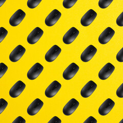 Rows of black plastic optical computer mouses on office table yellow color. Top view. Seamless pattern
