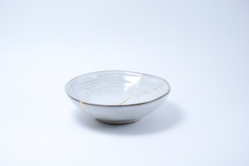 Kintsugi Japanese grey bowl. Gold cracks restoration on pottery restored with the antique Kintsugi restoration technique. The beauty of imperfections. representation of trauma. 