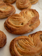 Homemade sweet bun with cinnamon and sugar on white paper background