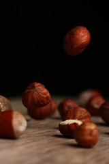 delicious hazelnuts falling on a dark background