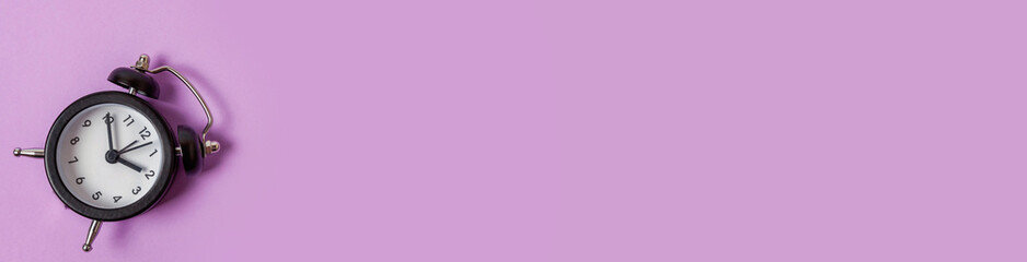 Simply minimal design ringing twin bell vintage classic alarm clock Isolated on purple background....