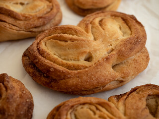 Homemade sweet bun with cinnamon and sugar on white paper background