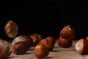 delicious hazelnuts falling on a dark background