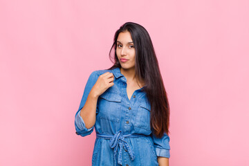 young woman looking arrogant, successful, positive and proud, pointing to self