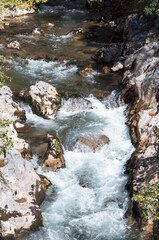 Rapid stream of water between stone rocks in the mountains