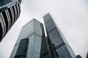Obraz premium mesmerizing geometry of skyscrapers receding into the clouds against a gray sky