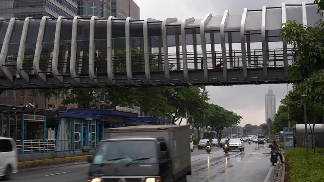 rainy day jakarta city downtown famous pedestrian bridge traffic street slow motion panorama 4k indonesia