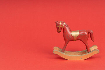 Red vintage rocking horse on red background