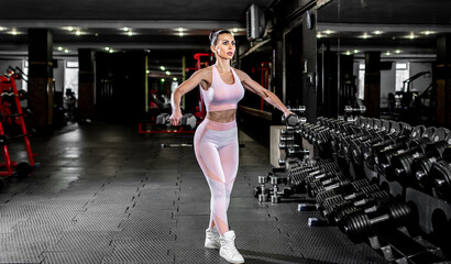 Fototapeta na wymiar Young girl lifting weights in the gym. healthy lifestyle concept