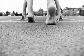 Close-up of barefoot athlete  ready for initial shot - Black and white