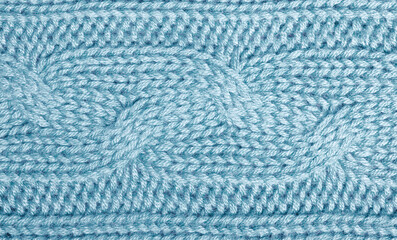 Blue knitted sweater fragment close-up. Blue woolen texture. Detailed warm yarn background. Natural woolen fabric.