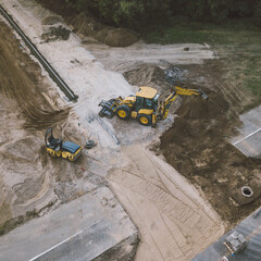 Construction site of new road in city. Heavy equipment. Pedestrian and bicycle asphalt road.