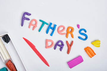 the inscription father's day from plasticine on a gray background