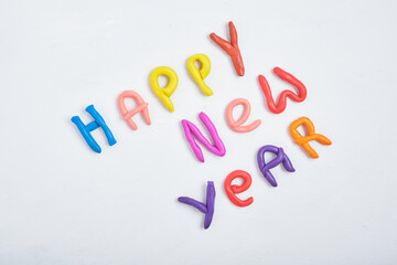 inscription happy new year from plasticine on a gray background