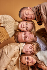 group of sleepy young people on each other, portrait of males and females in coats relaxing