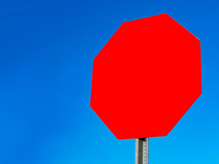 empty red stop sign with clear blue sky