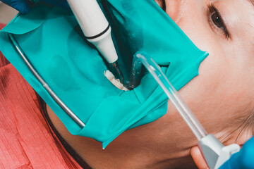 Treatment of posterior tooth, mouth covered with rubber dam, sterile treatment with modern technology.