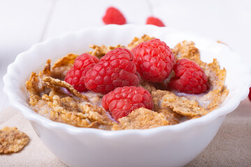breakfast with brown rice flakes, milk and fresh raspberries