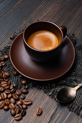 on the rustic wooden background, tasty and creamy Italian espresso in the cup