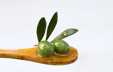 Shot of pouring fresh olive oil on a wooden spoon