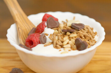 white yogurt with honet, cereal grain and fresh raspberries