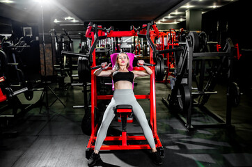 A girl in sportswear in a professional gym works out with fitness equipment. Healthy lifestyle...