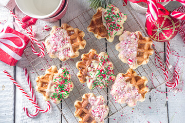 Stack of homemade Belgian waffles for Christmas breakfast. Traditional waffles dipped in white chocolate, with Candy Cane crumbs and festive sugar sprinkles