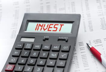 A calculator with the inscription INVEST . Business profit concept