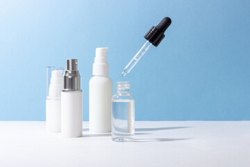 Set of white cosmetic bottles and jars with hard shadows. Beauty salon concept.