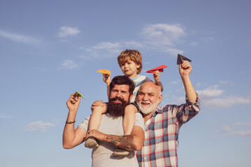 Three men generation. Cute son with dad playing outdoor. Fathers day - grandfather, father and son are hugging and having fun together.