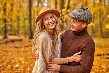 lovely couple posing in autumn forest, lovers walking in park. lovestory in forest. Man and Woman.happy couple outdoors