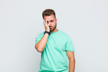 young man feeling bored, frustrated and sleepy after a tiresome, dull and tedious task, holding...