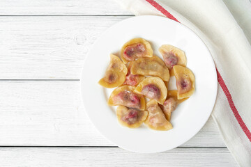 Russian dumplings on white plate on white wooden table
