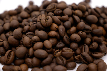 Large brown coffee beans on white background.