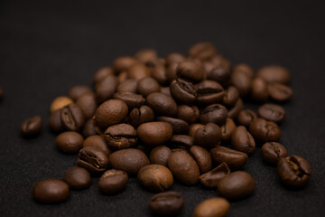Large brown coffee beans on black background